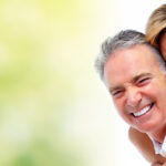 Happy smiling elderly couple over green background